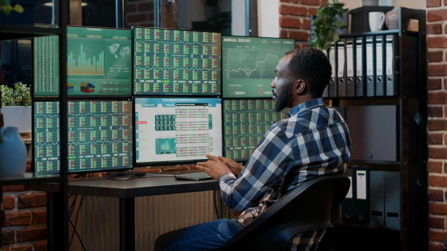 A finance professional analysing market data across multiple screens